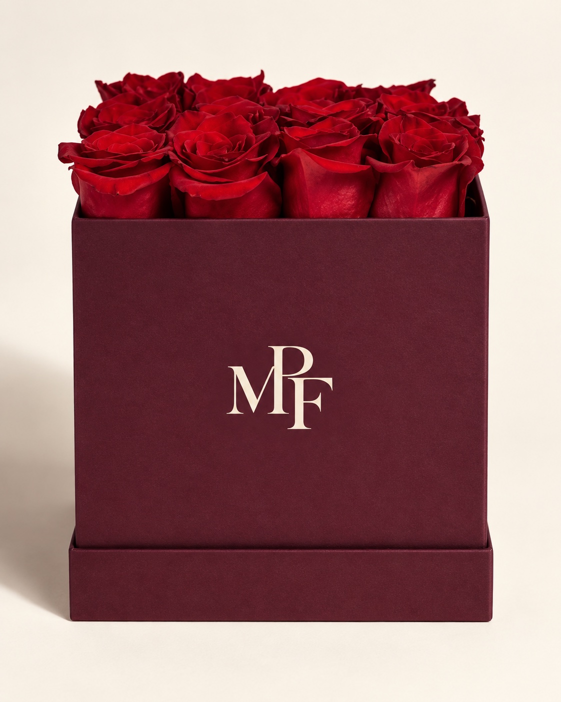 Rich red roses arranged in a square burgundy presentation box